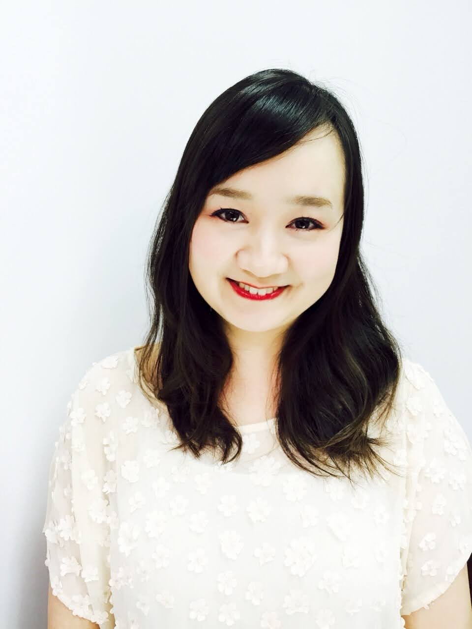 占い師 Acco の顔写真。白い背景の前で微笑んでいる